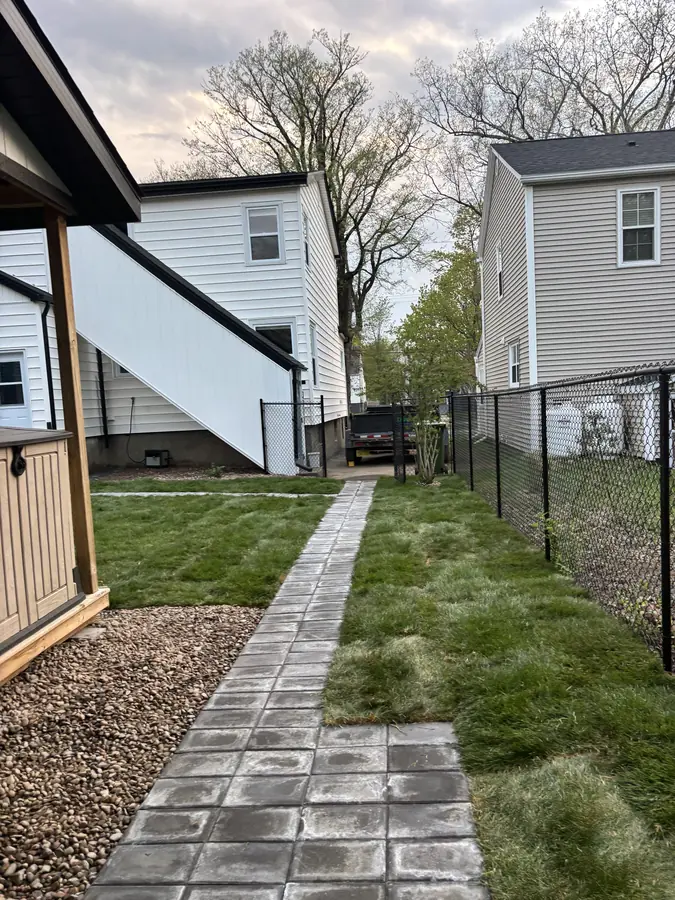 Paver pathway between gravel and fresh lawn along a fenced backyard — hardscaping project in Halifax, Nova Scotia