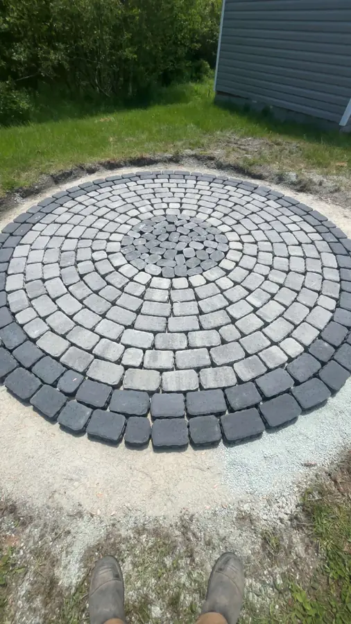 Circular interlocking paver patio in grey and charcoal laid in a fresh sand base — hardscaping project in Halifax, Nova Scotia